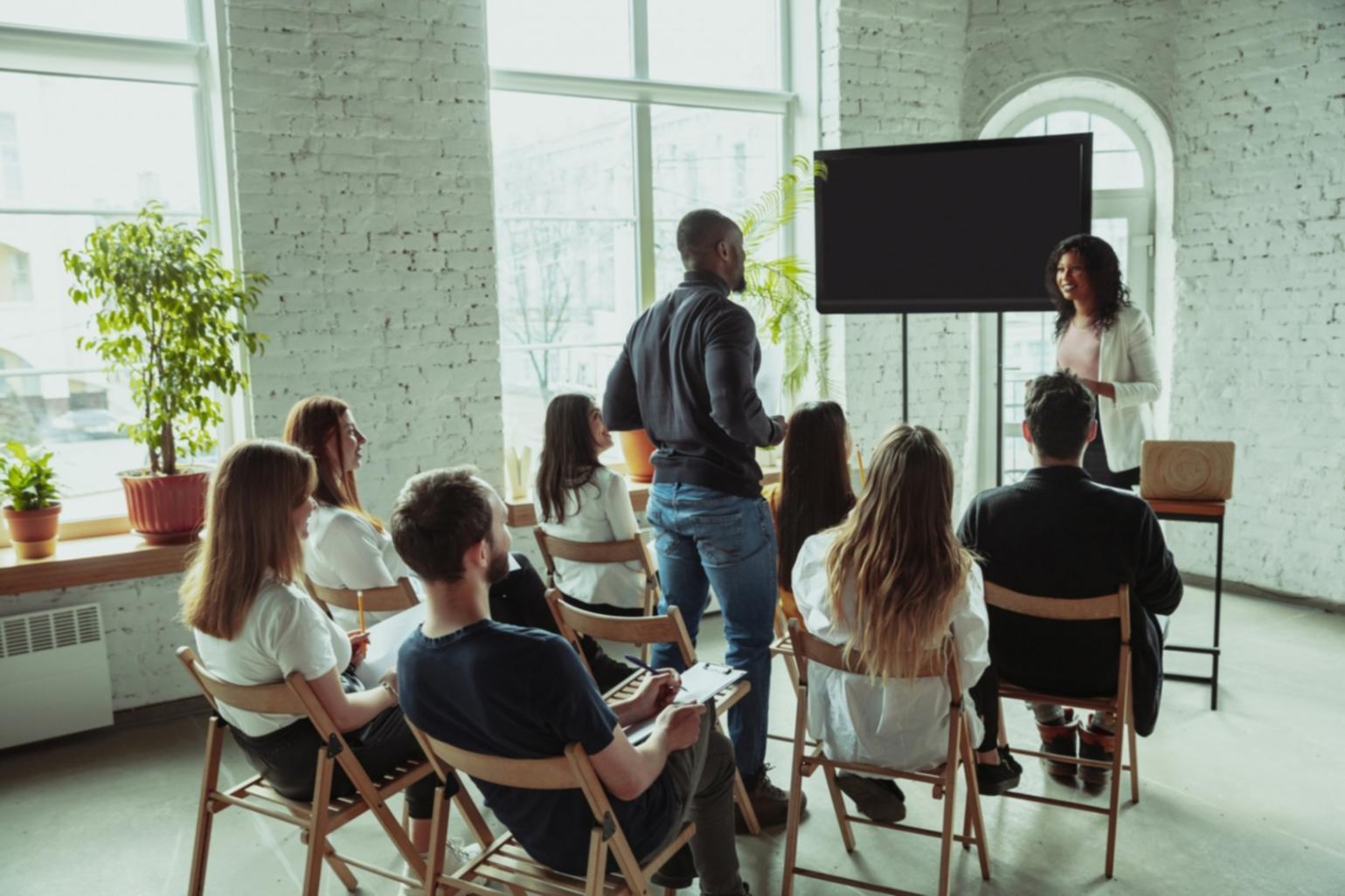 International students collaborating on business forecasting project in modern classroom setting